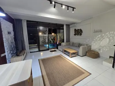 a living room with a couch and a table at Villa 2 Kavi Minimalis 1 Kamar Di Sanur in Sanur