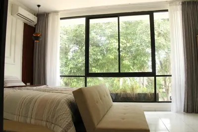 a bedroom with a bed and a large window at Villa 2 Kavi Minimalis 1 Kamar Di Sanur in Sanur