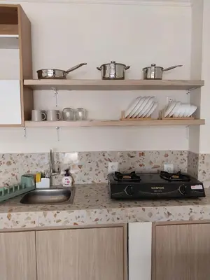 a kitchen counter with a stove and a sink at Villa 2 Kavi Minimalis 1 Kamar Di Sanur in Sanur