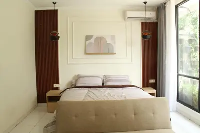 a bedroom with a bed and a picture on the wall at Villa 2 Kavi Minimalis 1 Kamar Di Sanur in Sanur