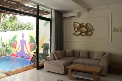 a living room with a couch and a sliding glass door at Villa 2 Kavi Minimalis 1 Kamar Di Sanur in Sanur