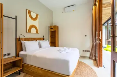 a bedroom with a large white bed and a window at Erianthe Peaceful 3 BR Private Pool Villa in Kerobokan