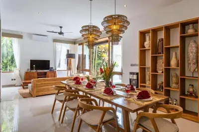 a dining room with a wooden table and chairs at Erianthe Peaceful 3 BR Private Pool Villa in Kerobokan