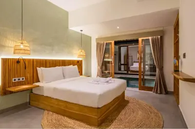 a bedroom with a bed and a swimming pool at Erianthe Peaceful 3 BR Private Pool Villa in Kerobokan