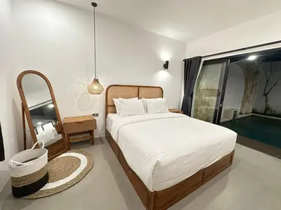 a bedroom with a bed and a large window at Della Solea Seminyak in Seminyak