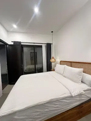a large white bed in a room with a window at Della Solea Seminyak in Seminyak
