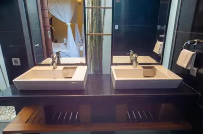 a bathroom with two sinks and a mirror at Mahita Garden Villa 3 Bedroom with Amazing view in Jimbaran
