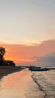 a boat sitting on the beach at sunset at Joand Skyline in Seminyak