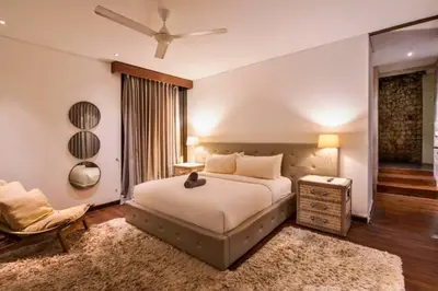 a bedroom with a bed and a chair and a window at Sayara Modern 3 BR Private Pool Villa in Seminyak