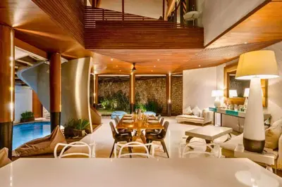 a living room with a table and chairs and a pool at Sayara Modern 3 BR Private Pool Villa in Seminyak