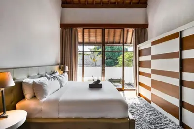 a bedroom with a bed and a large window at Sayara Modern 3 BR Private Pool Villa in Seminyak