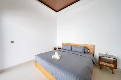 a bedroom with a large bed with a television at Il Petrucino Villa by Damaresa in Nusa Dua