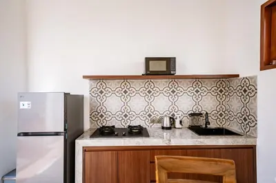 a kitchen with a stove and a refrigerator at Il Petrucino Villa by Damaresa in Nusa Dua