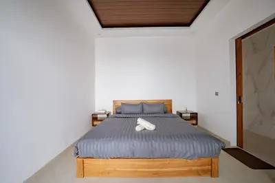a bedroom with a bed with a blue comforter at Il Petrucino Villa by Damaresa in Nusa Dua