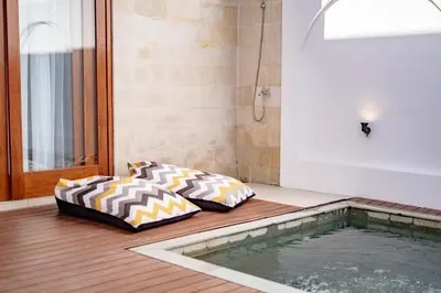 two beds sitting on the floor next to a swimming pool at Il Petrucino Villa by Damaresa in Nusa Dua