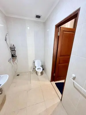 a bathroom with a toilet and a wooden door at Casa Danasa, secure and serene Villa at the heart of Seminyak with 24hr One Gate Security in Seminyak