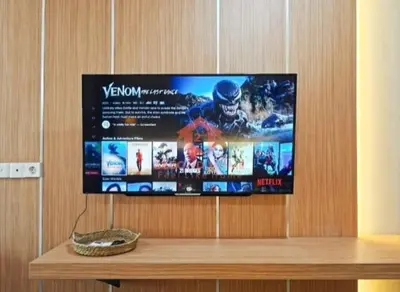 a flat screen tv hanging on a wooden wall at Newly Lavaya Resort 1BR with pool in Nusa Dua