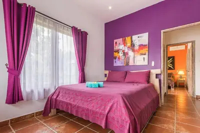 a bedroom with purple walls and a large bed at Villa emma, 2 bed with pool table & private pool in Seminyak