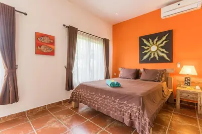 a bedroom with orange walls and a bed in a room at Villa emma, 2 bed with pool table & private pool in Seminyak