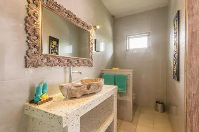 a bathroom with a stone sink and a mirror at Villa emma, 2 bed with pool table & private pool in Seminyak