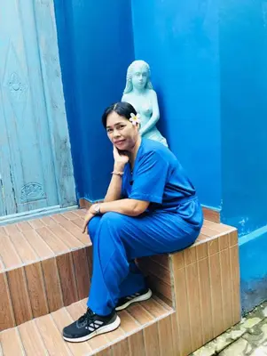 a woman sitting on a step in front of a statue at Villa emma, 2 bed with pool table & private pool in Seminyak