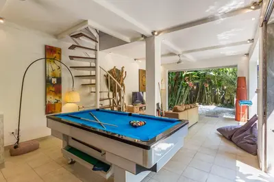 a pool table in a living room with a staircase at Villa emma, 2 bed with pool table & private pool in Seminyak