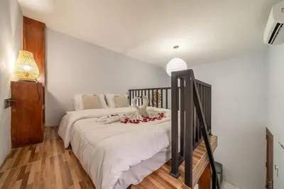 a bedroom with a bed with flowers on it at Cozy Mezzanine Near Airport & Jimbaran Beach in Ngurah Rai International Airport