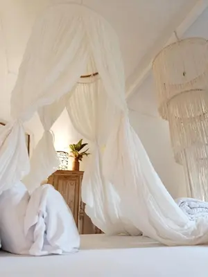a bedroom with white bedding and mosquito nets at Gusti Ayu Private Bali House - 2 Bedrooms near Canggu & Seminyak in Kerobokan