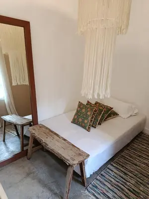 a bedroom with a bed with a bench and a window at Gusti Ayu Private Bali House - 2 Bedrooms near Canggu & Seminyak in Kerobokan
