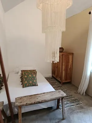 a bedroom with a bed and a bench and curtains at Gusti Ayu Private Bali House - 2 Bedrooms near Canggu & Seminyak in Kerobokan