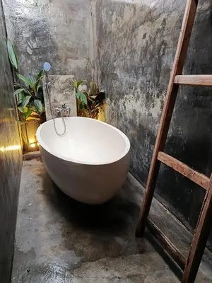 a white bath tub in a room with a ladder at Gusti Ayu Private Bali House - 2 Bedrooms near Canggu & Seminyak in Kerobokan