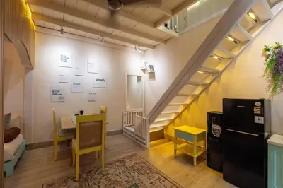 a room with a staircase and a table and chairs at Palm Villa 4 , Seminyak Center in Seminyak