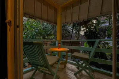 two chairs and a table with a candle on a porch at Palm Villa 4 , Seminyak Center in Seminyak