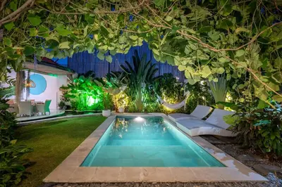a garden with a swimming pool in the middle at Villa 888 Eat Shop Play - 3BR Private Pool Oberoi in Seminyak