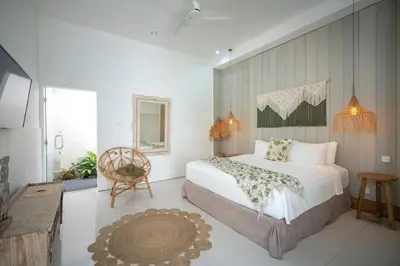 a bedroom with a large bed and a chair at Villa 888 Eat Shop Play - 3BR Private Pool Oberoi in Seminyak