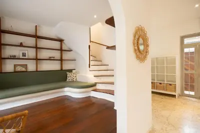 a living room with stairs and a green couch at Charming Two Bedroom Villa Near Seminyak Beach in Seminyak