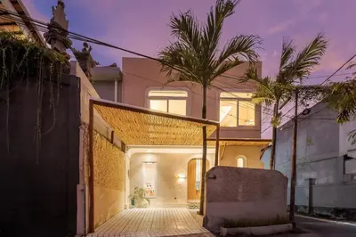 a house with palm trees on the side of it at The Shalak Villa Bali in Denpasar