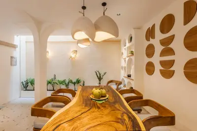a dining room with a wooden table and chairs at The Shalak Villa Bali in Denpasar
