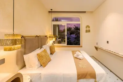 a large white bed in a room with a window at The Shalak Villa Bali in Denpasar