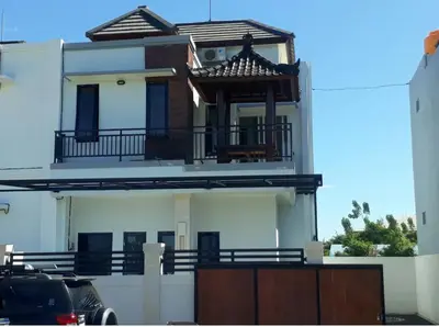 a large white house with a balcony on top of it at Chandra's house in Pesanggaran