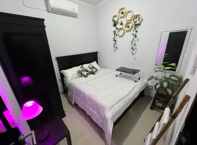 a bedroom with a bed with a laptop on it at Chandra's house in Pesanggaran