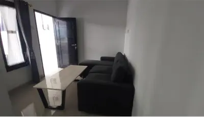 a living room with a black couch and a table at Chandra's house in Pesanggaran