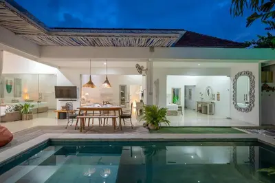 a villa with a swimming pool and a dining room at Villa GR888 - 3BR Tropical Comfort Seminyak in Seminyak