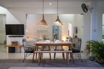 a dining room with a wooden table and chairs at Villa GR888 - 3BR Tropical Comfort Seminyak in Seminyak