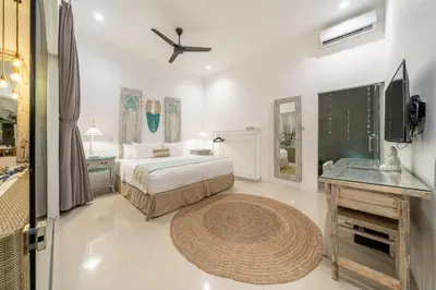 a bedroom with a bed and a television in it at Villa GR888 - 3BR Tropical Comfort Seminyak in Seminyak