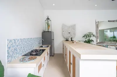 a kitchen with a sink and a stove in it at Villa GR888 - 3BR Tropical Comfort Seminyak in Seminyak