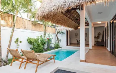 a villa with a swimming pool and two chairs at 2BR Villa - Central Seminyak - Private Cook & Breakfast in Seminyak