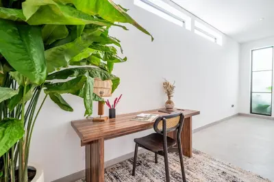 an office with a wooden desk and a plant at Villa Rice Kerobokan in Kerobokan