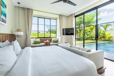 a bedroom with a large white bed and a pool at Villa Rice Kerobokan in Kerobokan