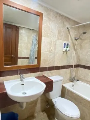 a bathroom with a toilet and a sink and a mirror at The Beach Residence at Jayakarta Resort Bali in Seminyak
